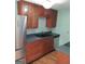 Kitchen featuring a stainless steel refrigerator, dark countertops, and wood cabinets at 32 Highland Ne Dr, Atlanta, GA 30305