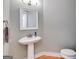 Small half bath features a pedestal sink, decorative mirror, and natural light at 507 Rippling Dr, Temple, GA 30179