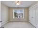 Bedroom featuring neutral carpeting, a ceiling fan, a window, and closet space, providing comfort and convenience at 507 Rippling Dr, Temple, GA 30179