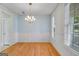 Bright dining room with hardwood floors, wainscoting, modern chandelier and natural light at 507 Rippling Dr, Temple, GA 30179