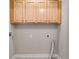Laundry room with upper cabinets and utility hookups, offering convenience and storage space for laundry needs at 507 Rippling Dr, Temple, GA 30179