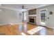Open living room featuring a stone fireplace, wood floors, and natural light from windows and a glass door at 507 Rippling Dr, Temple, GA 30179