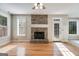 Spacious living room with a stone fireplace, wood floors, and windows offering natural light at 507 Rippling Dr, Temple, GA 30179