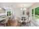 Bright dining area with hardwood floors, a glass table, and chairs, complemented by a modern chandelier and natural light at 1000 Arbor Forest Sw Way # 1000, Marietta, GA 30064