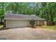 Exterior shot of a house with a two-car garage and lush greenery around the property at 1000 Arbor Forest Sw Way # 1000, Marietta, GA 30064