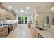 Bright kitchen featuring stainless appliances, light wood cabinetry, granite countertops, and large windows overlooking the backyard at 1000 Arbor Forest Sw Way # 1000, Marietta, GA 30064