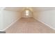 Finished attic with carpeting and a window providing natural light into the room at 205 Huntwood Ct, Ellenwood, GA 30294