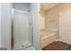 Bathroom featuring shower with glass doors and a tub under a window with blinds at 205 Huntwood Ct, Ellenwood, GA 30294