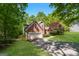 Two-story brick home with mature trees, an attached two-car garage, and beautiful lawn at 205 Huntwood Ct, Ellenwood, GA 30294