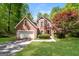 Charming brick home with a manicured lawn, mature trees, and an attached two car garage at 205 Huntwood Ct, Ellenwood, GA 30294
