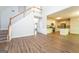 Open-concept floor plan with staircase, laminate floors, and view into kitchen at 205 Huntwood Ct, Ellenwood, GA 30294