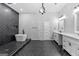 Modern bathroom showcasing a soaking tub, double vanity, and elegant fixtures on dark herringbone tile flooring at 378 Grant Park Se Pl, Atlanta, GA 30315