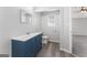 Contemporary bathroom features blue vanity with a sink, toilet, and modern fixtures at 3941 Kings Pl, Ellenwood, GA 30294