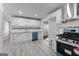 Bright kitchen with white cabinetry, granite countertops, blue appliances, and stylish gray flooring at 3941 Kings Pl, Ellenwood, GA 30294