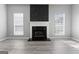 Cozy living room featuring a decorative fireplace with black accents and three bright windows at 3941 Kings Pl, Ellenwood, GA 30294