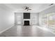 Bright living room with stone fireplace, ceiling fan, and large windows providing ample natural light at 3941 Kings Pl, Ellenwood, GA 30294