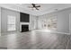 Open-concept living room featuring a brick fireplace, ceiling fan, and multiple windows for natural lighting at 3941 Kings Pl, Ellenwood, GA 30294