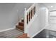 Interior staircase with wooden steps and white railings, leading to an open kitchen area at 3941 Kings Pl, Ellenwood, GA 30294