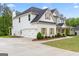 A two-story white home featuring an attached two-car garage and a long driveway, set on a large private lot at 152 Creekrise Pl, Palmetto, GA 30268