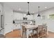 Modern white kitchen with a large island, pendant lighting, and stainless steel appliances at 152 Creekrise Pl, Palmetto, GA 30268