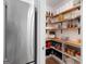 Pantry with stainless steel refrigerator and open wooden shelves holding a variety of snacks and food items at 152 Creekrise Pl, Palmetto, GA 30268