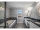 Bathroom with double vanity, oval mirrors, large tub, and a view to the exterior at 2548 Kickerillo Se Way, Atlanta, GA 30316