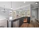 Spacious kitchen island with stainless steel dishwasher and sink, black cabinets, granite countertops, open to living space at 2548 Kickerillo Se Way, Atlanta, GA 30316