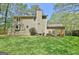 View of rear of house with yard, including wood deck, manicured lawn and mature trees at 401 Waterwood Bnd, Peachtree City, GA 30269