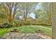 Spacious backyard with mature trees, wooden planters, green lawn and wooden deck at 401 Waterwood Bnd, Peachtree City, GA 30269