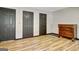 A finished bedroom with hardwood flooring, neutral walls, and three doors for access at 401 Waterwood Bnd, Peachtree City, GA 30269