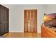 This cozy bedroom features a closet with folding wooden doors and natural hardwood floors at 401 Waterwood Bnd, Peachtree City, GA 30269