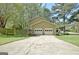 Exterior view of home with a two-car garage, cracked driveway, and well-kept lawn at 401 Waterwood Bnd, Peachtree City, GA 30269