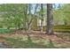 Wooded home exterior featuring tan siding, a wooden fence, and mature trees on a sunny day at 401 Waterwood Bnd, Peachtree City, GA 30269