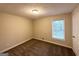 Bright bedroom featuring tan walls, brown carpet, a window, and a white door at 4397 Bluebird Ln, Lithia Springs, GA 30122