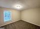 Carpeted bedroom features neutral walls and a window offering natural light at 4397 Bluebird Ln, Lithia Springs, GA 30122