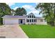 Charming single-story home with a well-maintained lawn, a two-car garage and a beautiful window design at 4397 Bluebird Ln, Lithia Springs, GA 30122