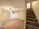 Carpeted living room features stairs to the second floor at 4397 Bluebird Ln, Lithia Springs, GA 30122