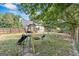 View of the expansive backyard featuring a wooden fence, playset with swings, and shady trees at 127 Muirwood Dr, Temple, GA 30179