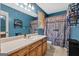 Bright bathroom featuring a light countertop, blue walls, and a unique barn-style shower curtain at 127 Muirwood Dr, Temple, GA 30179