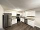 Well-lit kitchen featuring stainless steel appliances, white cabinets, granite countertops, and modern luxury vinyl plank at 3995 Willowbrook Dr, Douglasville, GA 30135