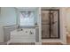 Relaxing bathroom featuring a soaking tub, shower, and wood look tile floor at 2060 Lake St, Loganville, GA 30052