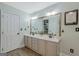 Bright bathroom with a double sink vanity, framed mirror, and decorative artwork at 2060 Lake St, Loganville, GA 30052