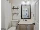 Neat bathroom includes a toilet, sink, and vanity with shelving at 2060 Lake St, Loganville, GA 30052