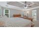 A primary bedroom showcases neutral walls, natural light, and wood furniture with a tray ceiling and a ceiling fan at 2060 Lake St, Loganville, GA 30052