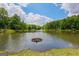 Scenic lake view surrounded by lush greenery under a bright blue, partly cloudy sky, creating a serene and inviting atmosphere at 2060 Lake St, Loganville, GA 30052
