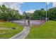 The community tennis court features a fence and a walkway with green space all around at 2060 Lake St, Loganville, GA 30052