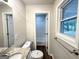 Neutral bathroom offers granite vanity, framed mirror, new toilet, window, and view to another bathroom at 2930 Waters Rd, Atlanta, GA 30354