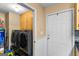 Well-organized laundry room with modern washer and dryer, storage cabinets, and an exterior door for convenience at 425 Wendy Ct, Mcdonough, GA 30252