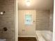 Modern bathroom features gray tiled walls, window above the tub, and updated fixtures at 660 Thomasville Se Blvd, Atlanta, GA 30315