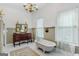 Bright bathroom features a clawfoot tub, antique vanity, and elegant chandelier at 29 Indian Creek Rd, Locust Grove, GA 30248